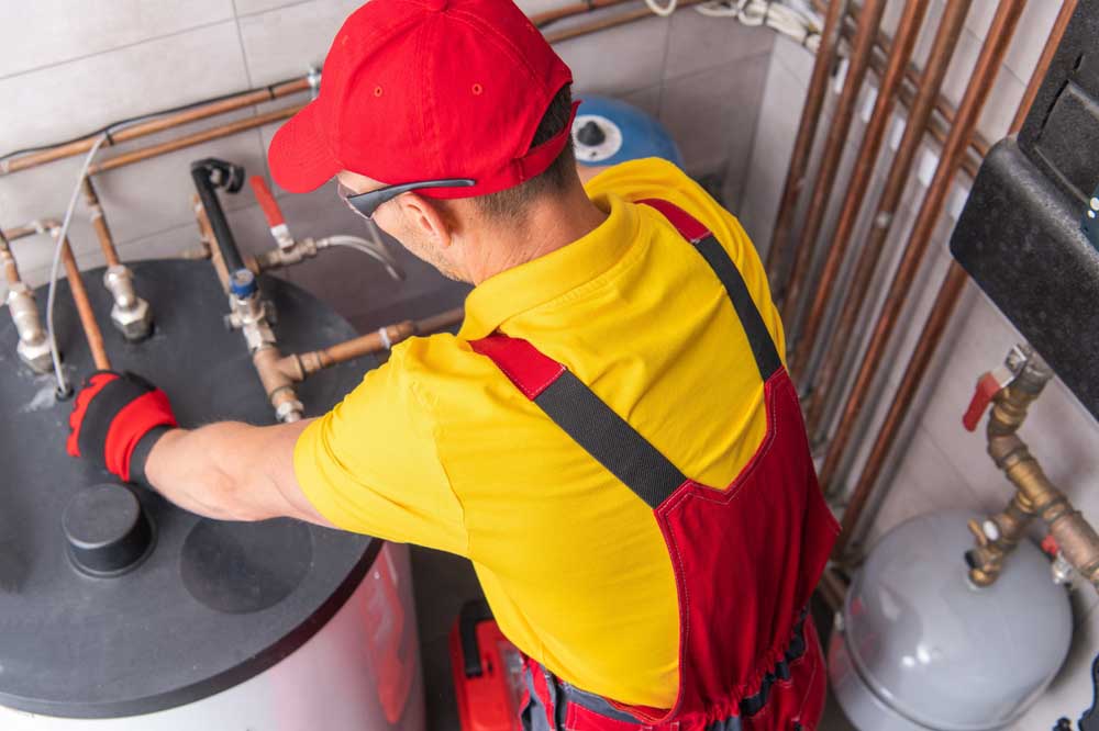 Plumber Repairing Tank Water Heater in Boiler Room Chapin, SC