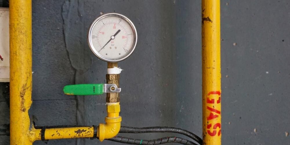 digital pressure gauge connected to plumbing line