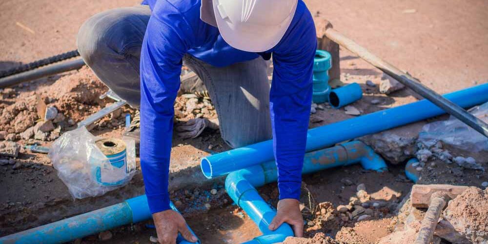 Plumber working on a busted pipe line